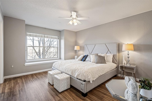 bedroom with ceiling fan, a textured ceiling, and dark hardwood / wood-style flooring