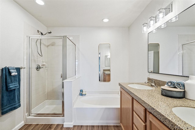 bathroom featuring vanity, hardwood / wood-style flooring, and plus walk in shower