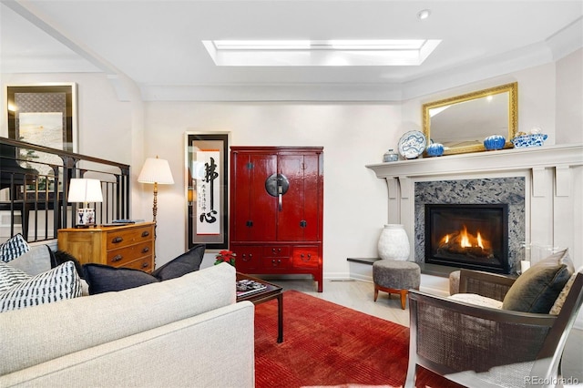 living area featuring a skylight, wood finished floors, and a high end fireplace