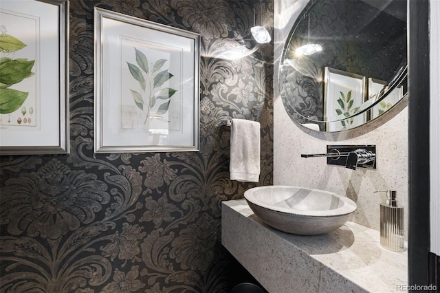 bathroom featuring wallpapered walls and a sink