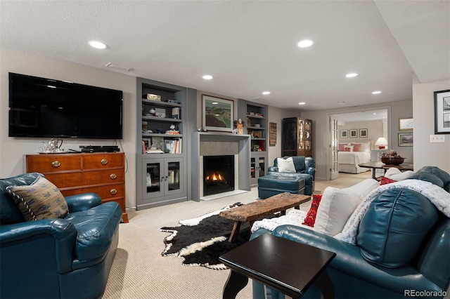 living room with a fireplace with flush hearth, built in shelves, carpet flooring, and recessed lighting