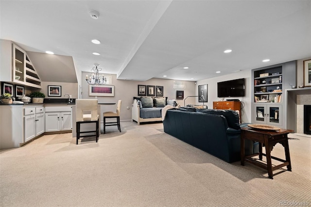 living room with recessed lighting, light colored carpet, a fireplace, and an inviting chandelier