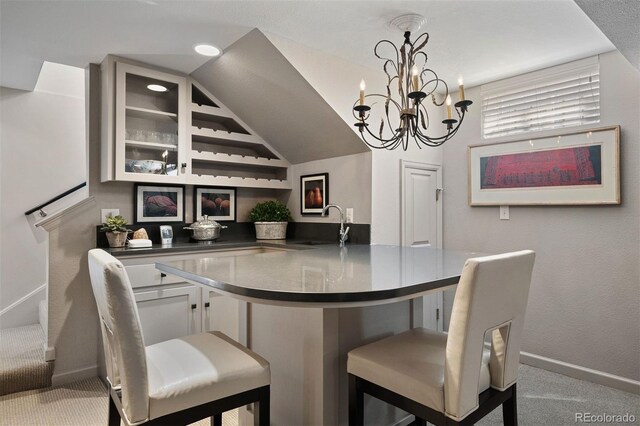 bar with indoor wet bar, carpet flooring, a sink, and baseboards