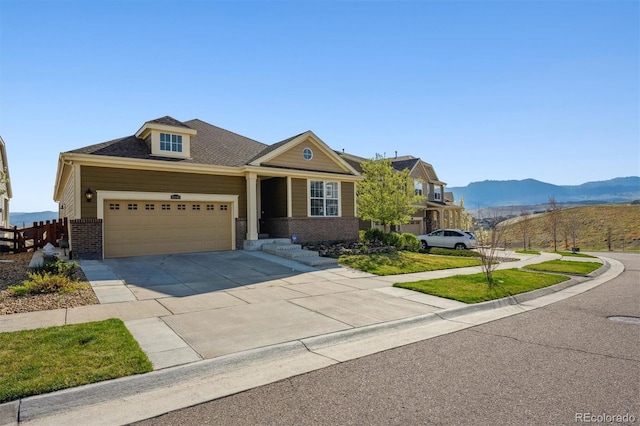 craftsman house featuring an attached garage, concrete driveway, brick siding, and a mountain view