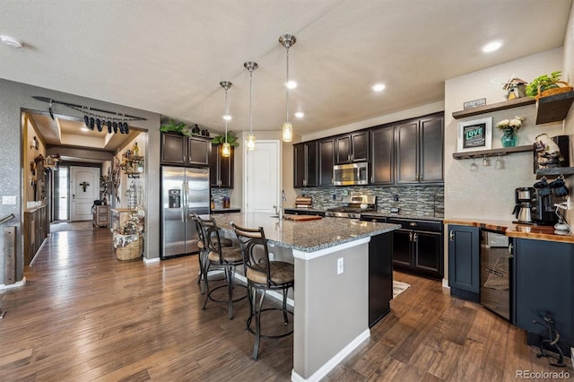 kitchen featuring beverage cooler, stainless steel appliances, tasteful backsplash, and dark wood-style floors
