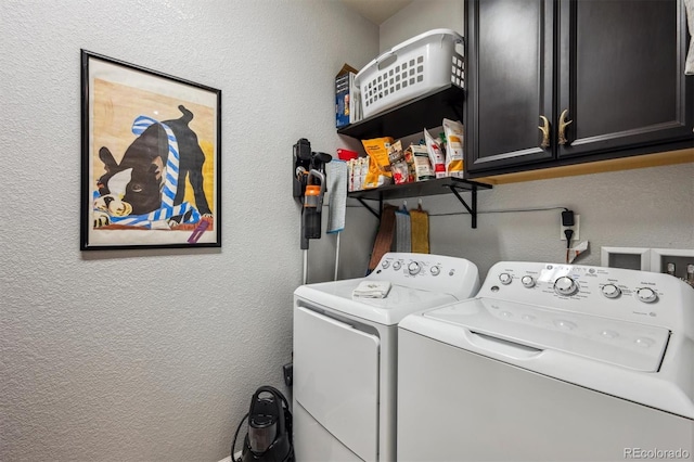 laundry area with cabinet space, washer and clothes dryer, and a textured wall