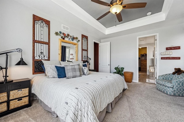 bedroom with baseboards, visible vents, crown molding, a raised ceiling, and light colored carpet