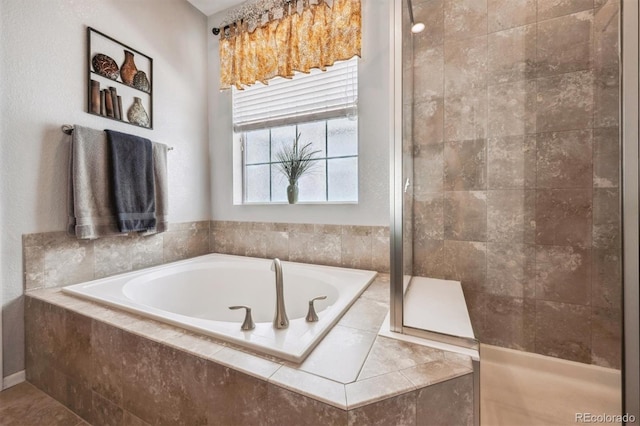 full bathroom featuring a tile shower and a bath