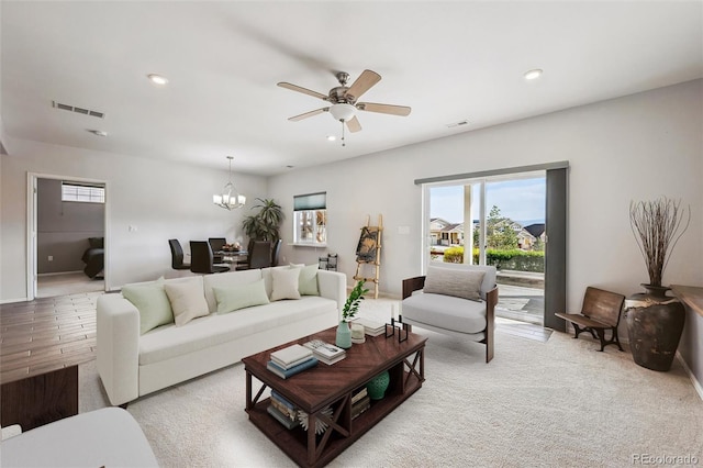 living area featuring recessed lighting, visible vents, and ceiling fan with notable chandelier