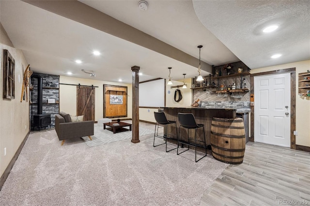 bar featuring a barn door, baseboards, bar area, and recessed lighting