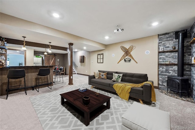 living area featuring stairway, light colored carpet, a wood stove, and bar
