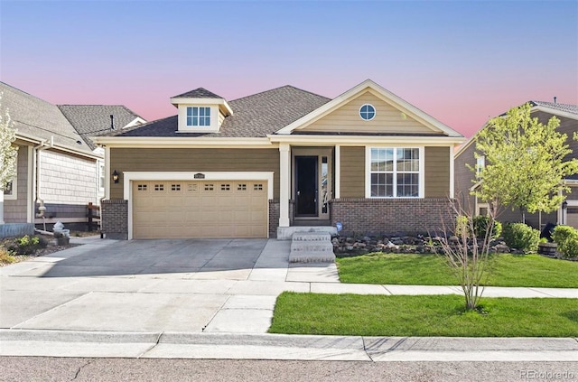 view of front of home with concrete driveway, a front lawn, brick siding, and an attached garage