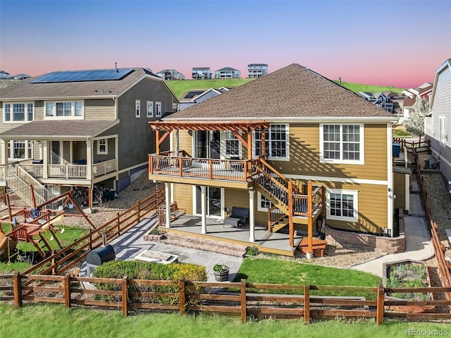 back of property featuring a patio, a residential view, a wooden deck, stairway, and a fenced backyard