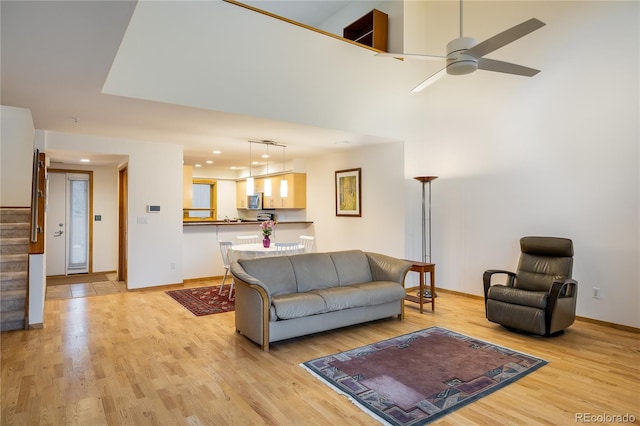 living room with ceiling fan and light wood-type flooring