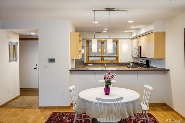 dining space with sink and light hardwood / wood-style flooring