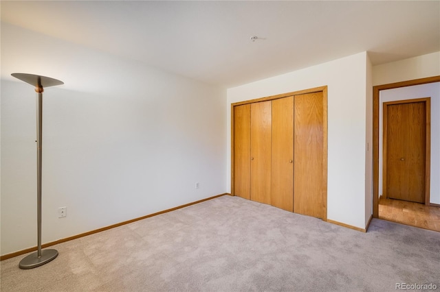 unfurnished bedroom featuring a closet and light carpet