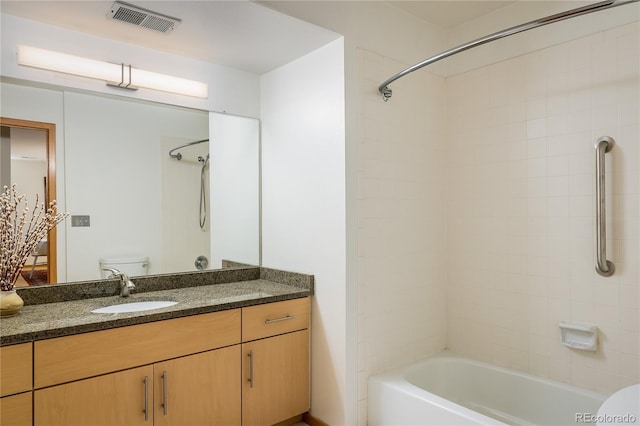 full bathroom featuring vanity, tiled shower / bath, and toilet