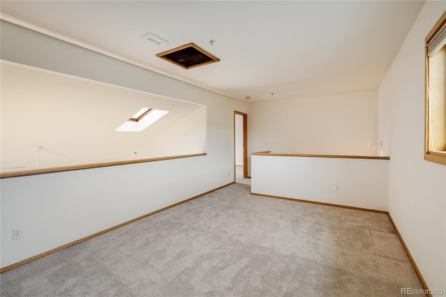 unfurnished room featuring light carpet and a skylight