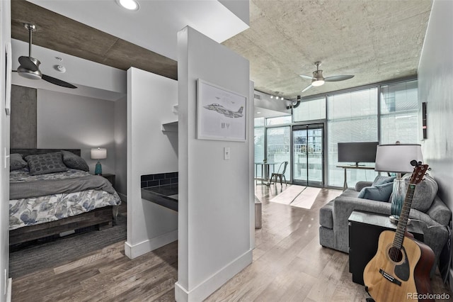1700 Bassett St Unit 820, Denver, CO 80202 - bedroom with expansive windows, wood finished floors, baseboards, and ceiling fan