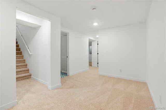 empty room with recessed lighting, light carpet, baseboards, and stairs