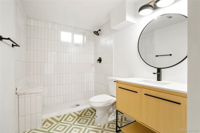 bathroom featuring toilet, a stall shower, visible vents, and vanity