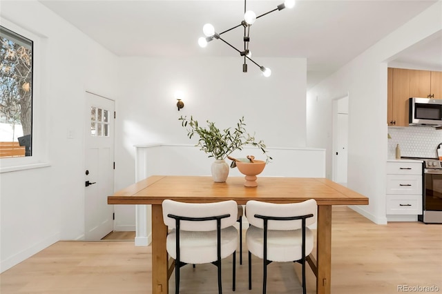 dining space featuring light wood-style floors and baseboards