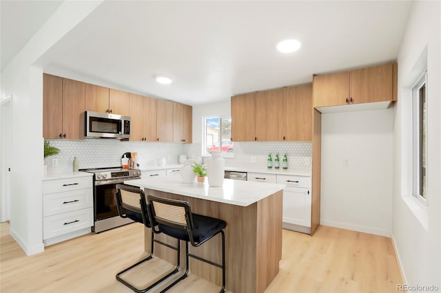 kitchen featuring appliances with stainless steel finishes, light countertops, and white cabinetry