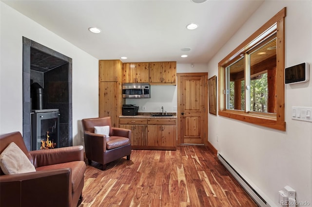 1000 Rangeview Ct, Black Hawk, CO 80422 - kitchen featuring stainless steel microwave, baseboard heating, recessed lighting, wood finished floors, and brown cabinetry
