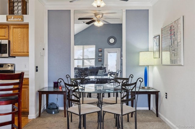 dining space with light carpet, ornamental molding, vaulted ceiling, and a ceiling fan