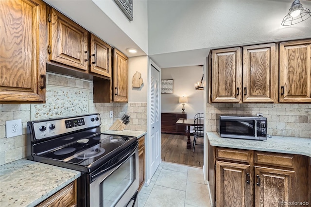 10397 Yates Ct, Westminster, CO 80031 - kitchen featuring electric stove, decorative backsplash, light tile patterned floors, and brown cabinetry