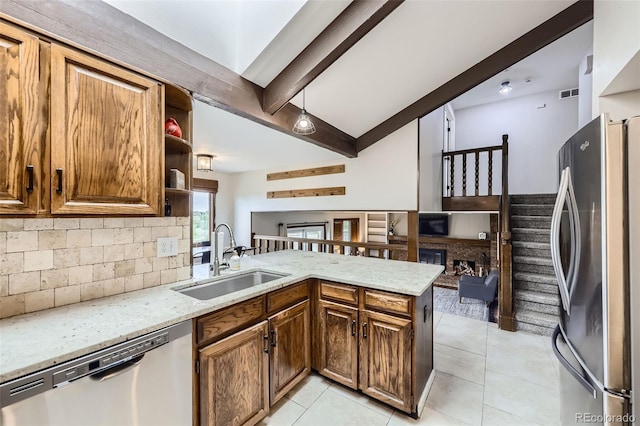 10397 Yates Ct, Westminster, CO 80031 - kitchen featuring appliances with stainless steel finishes, a sink, decorative backsplash, light stone counters, and a peninsula