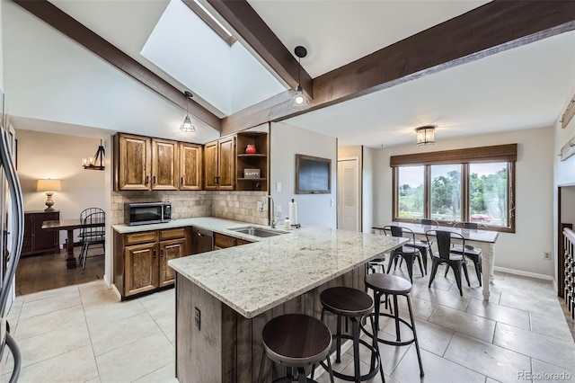10397 Yates Ct, Westminster, CO 80031 - kitchen featuring a sink, a peninsula, appliances with stainless steel finishes, open shelves, and tasteful backsplash