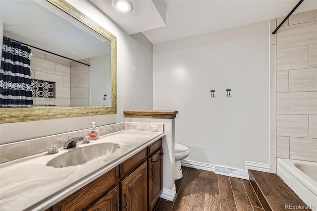 10397 Yates Ct, Westminster, CO 80031 - bathroom with toilet, vanity, wood finished floors, baseboards, and shower / tub combo
