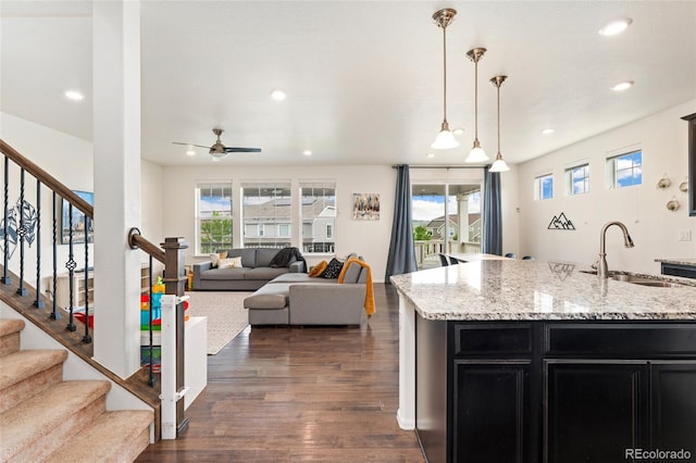 19316 W 84th Pl, Arvada, CO 80007 - kitchen with dark cabinetry, dark wood finished floors, recessed lighting, a ceiling fan, and light stone countertops