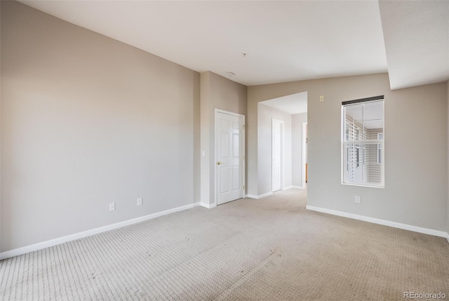 carpeted spare room with lofted ceiling