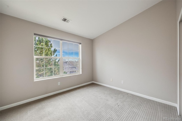 spare room featuring carpet flooring, lofted ceiling, and a wealth of natural light