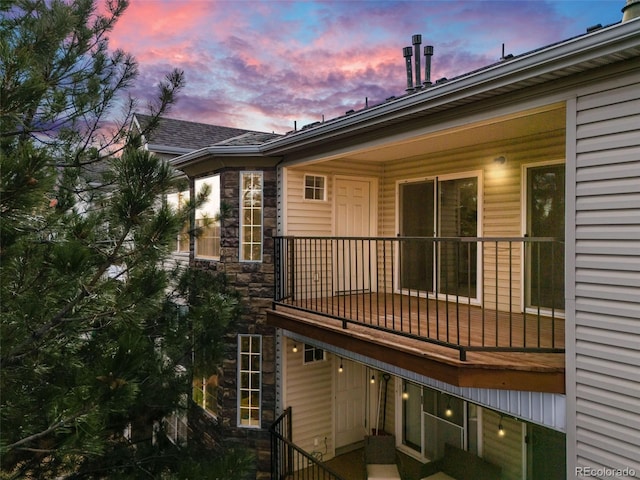 back house at dusk with a balcony