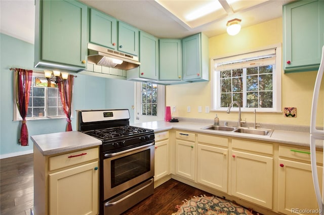 kitchen featuring stainless steel range with gas cooktop, sink, kitchen peninsula, and dark hardwood / wood-style floors