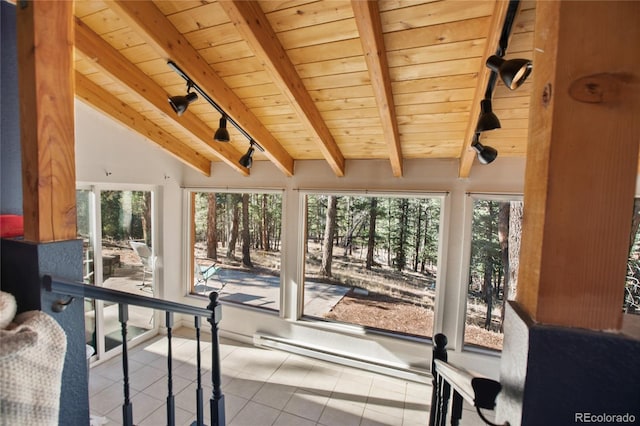 sunroom / solarium featuring lofted ceiling with beams, wood ceiling, rail lighting, and plenty of natural light