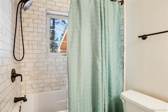 bathroom featuring shower / bath combination with curtain and toilet