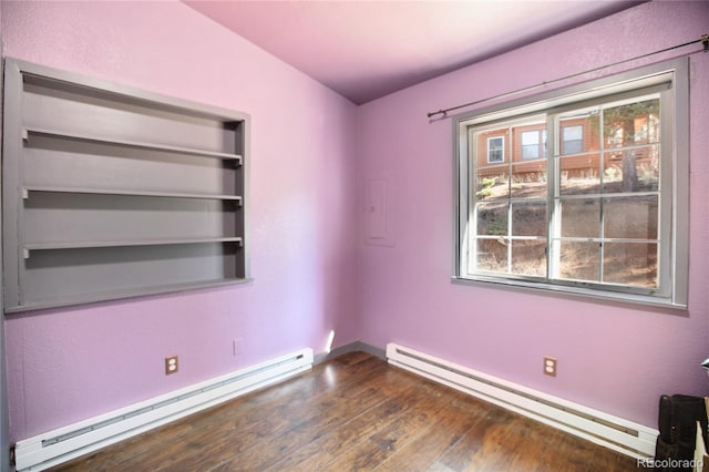 empty room with dark hardwood / wood-style flooring and baseboard heating