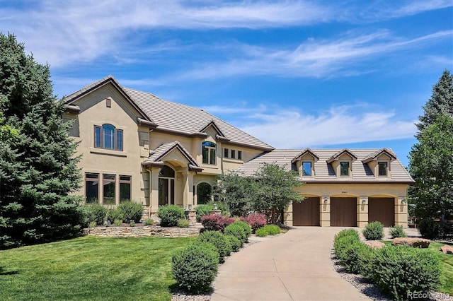 9065 E Lost Hill Trl, Lone Tree, CO 80124 - view of front facade featuring concrete driveway, an attached garage, a front lawn, stucco siding, and a tiled roof