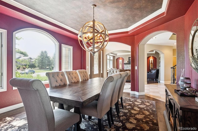 9065 E Lost Hill Trl, Lone Tree, CO 80124 - dining space with a chandelier, arched walkways, wood finished floors, crown molding, and a tray ceiling