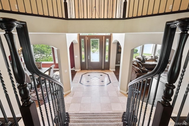 9065 E Lost Hill Trl, Lone Tree, CO 80124 - foyer entrance with arched walkways, a towering ceiling, and tile patterned flooring