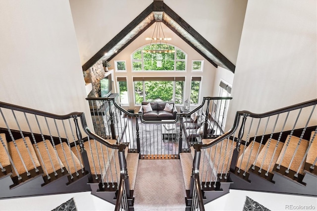 9065 E Lost Hill Trl, Lone Tree, CO 80124 - stairway featuring high vaulted ceiling, a chandelier, and carpet flooring