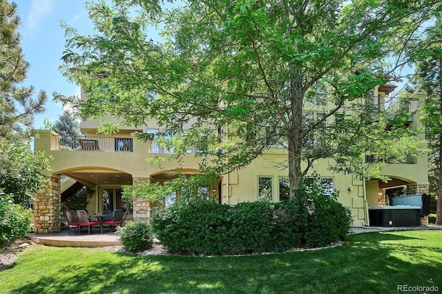 9065 E Lost Hill Trl, Lone Tree, CO 80124 - rear view of house with a balcony, a patio, stucco siding, and a yard