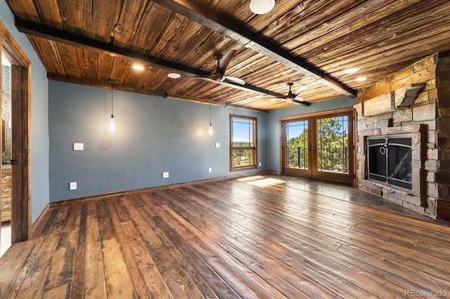 unfurnished living room featuring beamed ceiling, ceiling fan, a fireplace, dark hardwood / wood-style flooring, and wooden ceiling