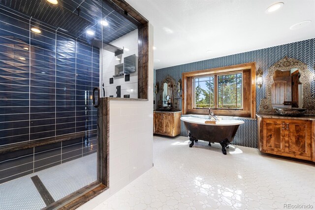 bathroom featuring tile walls, plus walk in shower, vanity, and tile flooring