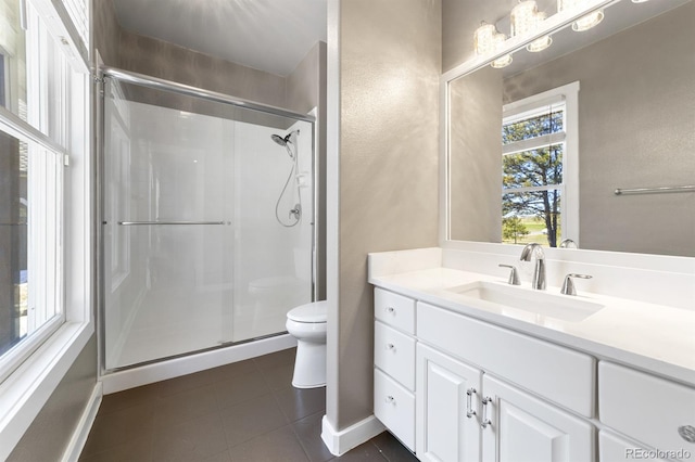 bathroom with tile floors, a shower with shower door, toilet, and vanity with extensive cabinet space