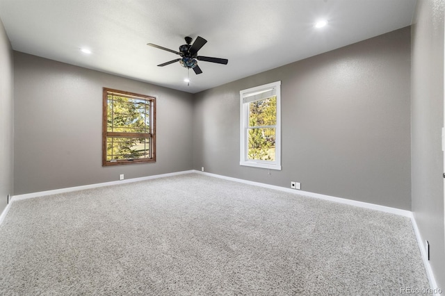 carpeted spare room with ceiling fan